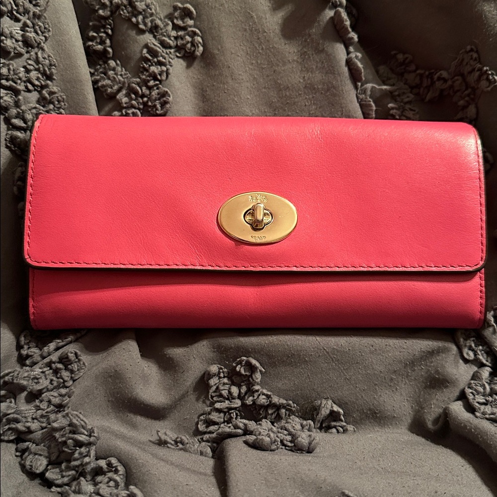 This is a Coach Turnlock Slim Envelope Wallet in pink leather.